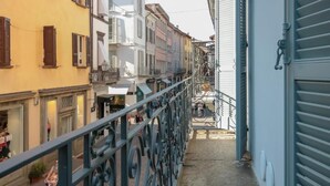 Un callejón estrecho flanqueado por edificios, una barandilla metálica y una escalera que desciende.