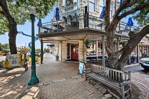 Ein Gebäude mit einer Stein-Fassade, einem Balkon mit blauen Sonnenschirmen und einem Schild für ein Restaurant.
