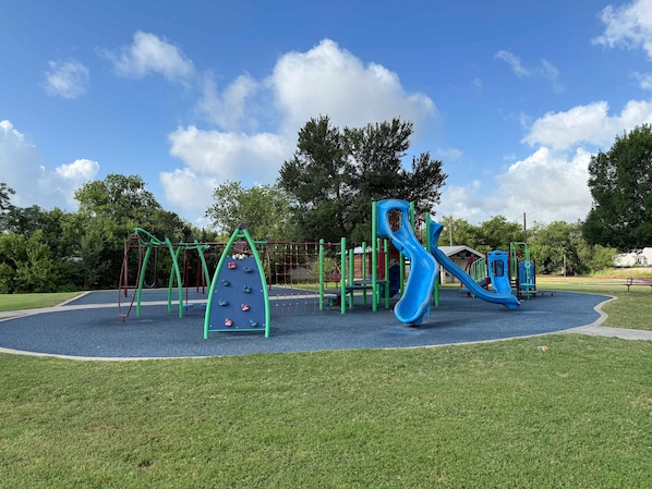 A playground with various play structures including a slide and climbing frames.