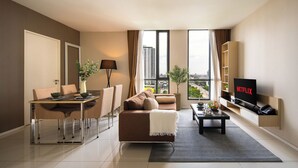 Una sala moderna con sofá, mesa de centro, televisor y comedor.