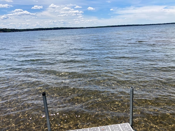 Vista clara de um lago com um píer que se estende sobre a água.