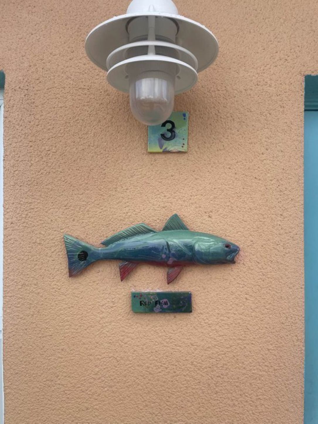 Ein an der Wand befestigtes Schild mit der Aufschrift '3' und eine Fischdekoration.