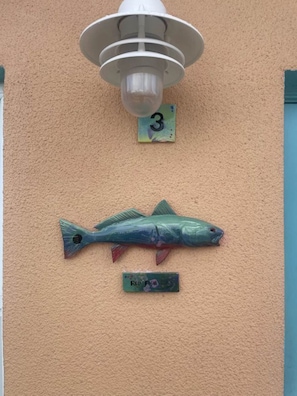 Ein an der Wand befestigtes Schild mit der Aufschrift '3' und eine Fischdekoration.