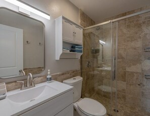 A bathroom with a sink, toilet, and shower. - 1 bedroom apartment in Saint James City with AC -Tarpon Suite (Saint James City)