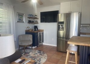 A compact kitchen with a refrigerator, a coffee maker, and a television mounted on the wall. - 1 bedroom apartment with AC Pompano Suite (Saint James City)