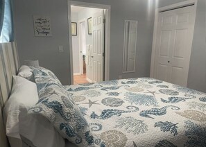 A bedroom with a bed, a door, and a hallway leading to another room. - 1 bedroom apartment with AC Pompano Suite (Saint James City)