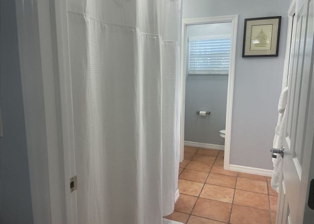 Un couloir étroit avec une porte donnant sur une salle de bain.