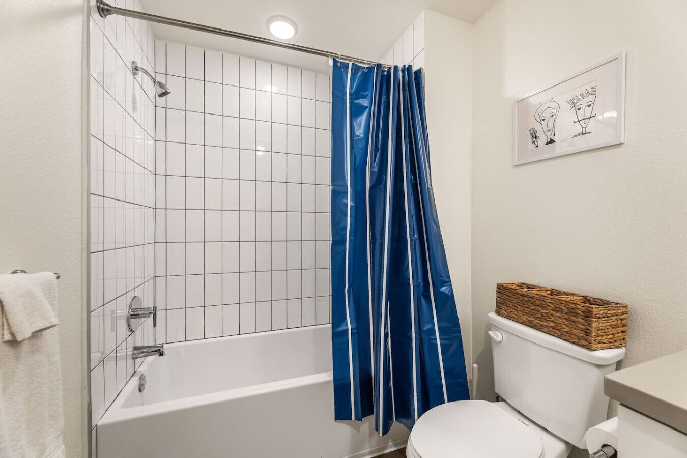Un baño con bañera, inodoro y cortina de ducha azul.