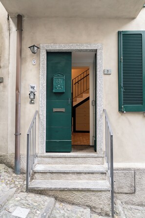 A stone staircase leading to a green door with a mailbox and a number '5' sign. - Casa Giada: a romantic little house on the lakefront (Varenna)