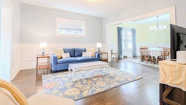 A living room with a blue sofa, a white coffee table, and a patterned rug. - Historic Home Downtown Gary Near BP/80/94 Hospital (Gary)