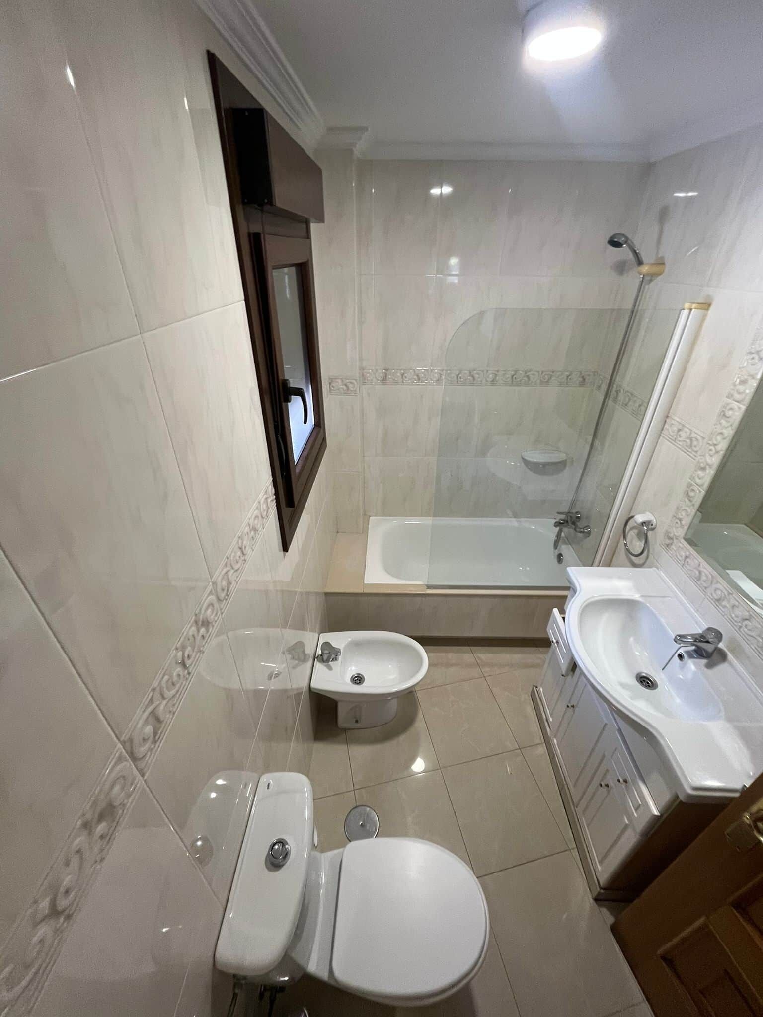 A bathroom with a toilet, bidet, bathtub, and sink.