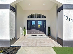 A building entrance with a double door, a number '1310' on the wall, and a doormat. - Coastal Retreat • Pool • Minutes from Beach (Englewood)