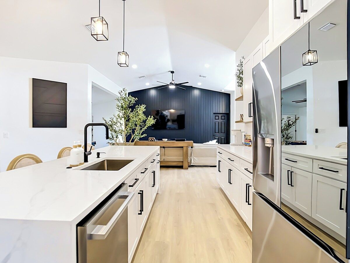 A modern kitchen with a central island, built-in appliances, and pendant lighting.