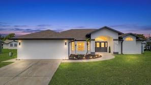 Einbungalow mit Garage, Auffahrt und gepflegtem Rasen.