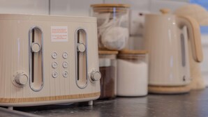 A kitchen with a vintage-style toaster, a kettle, and jars on the counter. - Crème Da La Casa (Coventry)