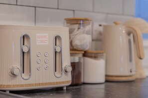 Una cocina con un tostador de estilo vintage, una tetera y frascos en la encimera.