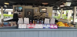 Un bancone gastronomico con diverse merendine confezionate e frutta fresca.