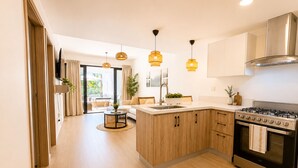 A modern kitchen with wooden cabinets, a gas stove, and pendant lighting. - 2BR Crystal Lagoon Retreat Puntacana Prive Pool (Punta Cana)