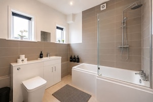 Un baño moderno con inodoro, lavabo y ducha.