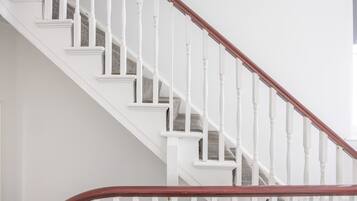 A staircase with white balusters and a wooden handrail.