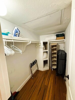 A compact storage closet with shelves, a hanging rack, and a shoe rack. - Cozy Downtown Vibe Near Everything Austin (Austin)
