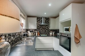 Eine moderne Küche mit Mikrowelle, Backofen und Spüle.