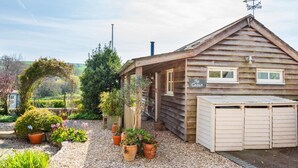 Eine Holzhütte mit überdachter Veranda, einer Garage und einem Schild mit der Aufschrift 'The Cabin'.
