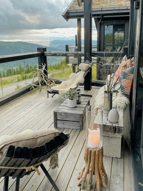 A wooden deck with a bench, a small table, and a candle holder. - Mountain cabin with panoramic view of Jotunheim (Hafjell)