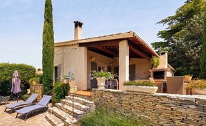 A house with a stone wall, a chimney, a patio with lounge chairs, and a garden. - CASA-La Tarente villa piscine et panorama vignes (Taradeau)