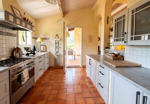A kitchen with white cabinets, a stove, and a tiled floor. - CASA-La Tarente villa piscine et panorama vignes (Taradeau)