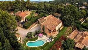 Una villa con piscina, immersa nel verde e circondata da un paesaggio collinare.