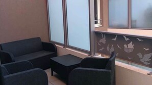 Un'area patio con divanetto, un tavolino e un pannello decorativo.