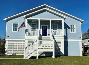 A two-story house with a front porch, a flag, and a garage. - Walk to Beach!- 3BR/2BA- Golf cart to Downtown BSL (Waveland)