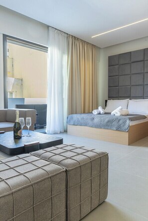 A modern hotel room with a bed, a seating area with a bottle and glasses, and a view through a window. - Tranquil AKVA Stay with Balcony in Piraeus (Athens)