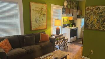 A living room with a sofa, coffee table, and artwork on the walls.