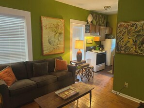 Ein Wohnzimmer mit einer Couch, einem Couchtisch und Kunstwerken an den Wänden.