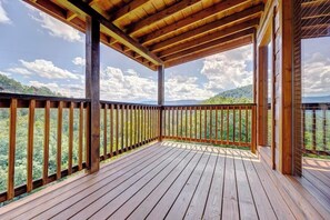 A wooden deck with a view of a mountainous landscape.