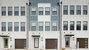 Un edificio de varios pisos con fachada simétrica, ventanas amplias y puertas de garaje.