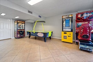 Ein Raum mit Spielautomaten, einem Tischtennis-Tisch und einer Tür.