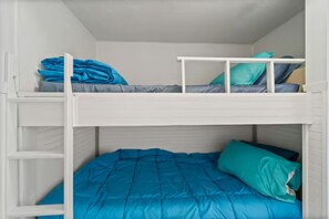 Ein Etagenbett mit zwei Schlafstellen, jeweils mit einer Matratze und Kissen.