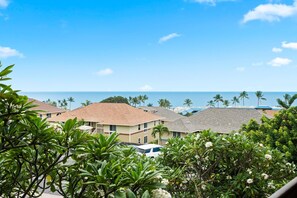 A coastal residential area with houses, a clear sky, and the ocean in the background. - Kona Mansions#208 (Kailua-Kona)