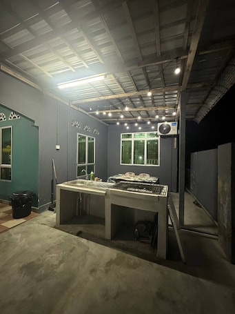 A room with a table, a sink, a window, and an air conditioning unit.