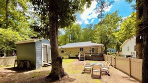 A backyard with a wooden table and chairs, a shed, and a house. - Offshore Tails, Relax with your pets in Ocean Pines, Near OCMD.  No pet fee! (Ocean Pines)