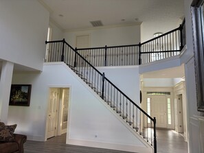A multi-level interior with a staircase, doors, and a framed artwork. - Beautiful Full of Light 6 Bedroom's House (Nicholasville)