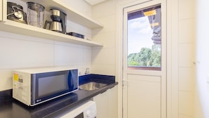 A compact kitchen with a microwave, coffee maker, and washing machine. - Apartment w/ Barbecue in Serra Gaucha Rad0501 (Canela)