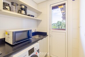 A compact kitchen with a microwave, coffee maker, and washing machine. - Apartment w/ Barbecue in Serra Gaucha Rad0501 (Canela)