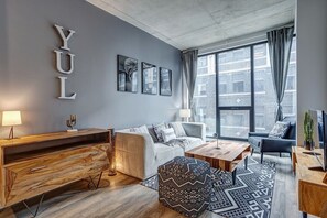 A modern living room with a sofa, coffee table, and a wooden side table. - Montreal - C Lofts Le Smith 2 Bedroom (Montreal)