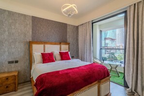 A bedroom with a large bed, a view of the city through a window, and a balcony with a glass table. - Furnished 1BR apartment with Fast WiFi, Workspace & Gym – Westlands (Nairobi)