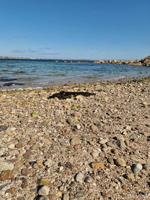 A rocky beach with clear water and distant rocky formations. - The Atlantic on Your Doorstep. The Point by the Sea. Charming house in Carraroe (Carraroe)