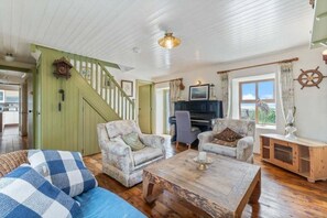 A cozy living room with a staircase, a piano, and a view of the outdoors. - The Atlantic on Your Doorstep. The Point by the Sea. Charming house in Carraroe (Carraroe)